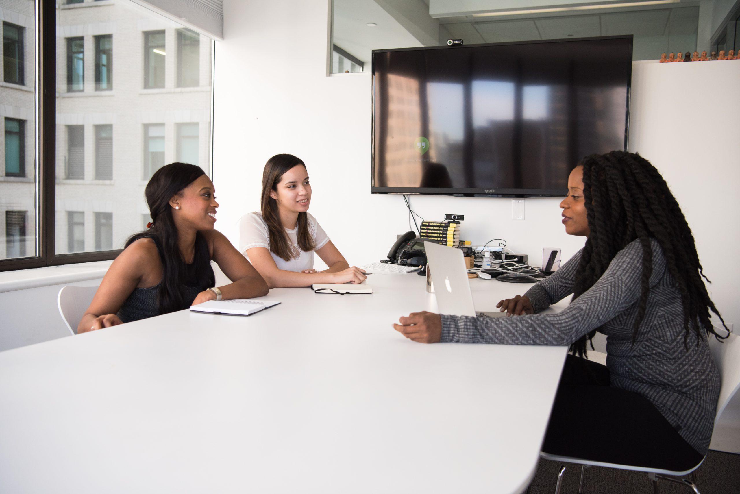 Three women having a meeting in a conference room.