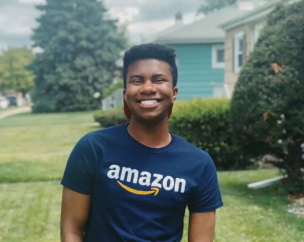 A smiling student wearing an Amazon t-shirt.