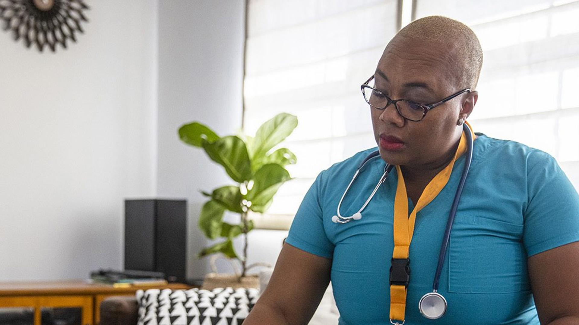 A woman in scrubs reading.