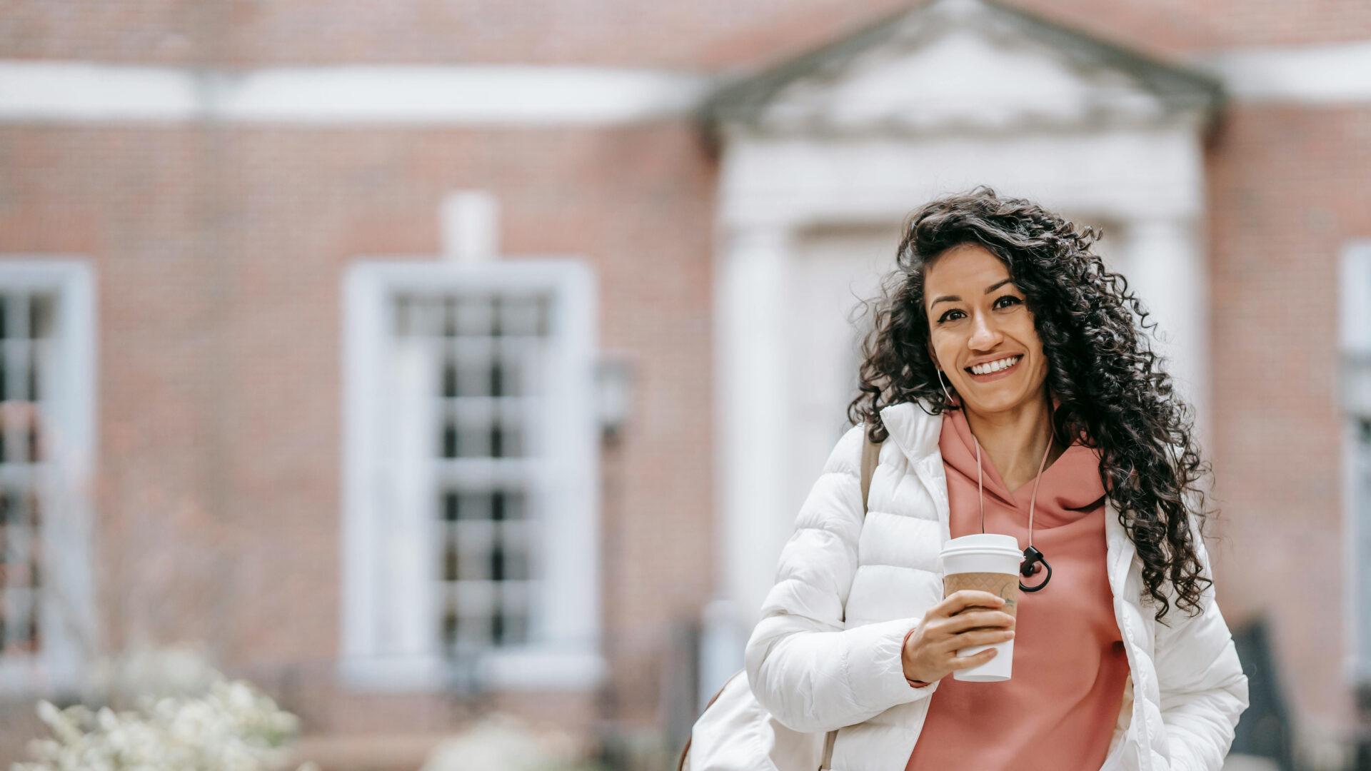 A confident student holding a coffee.