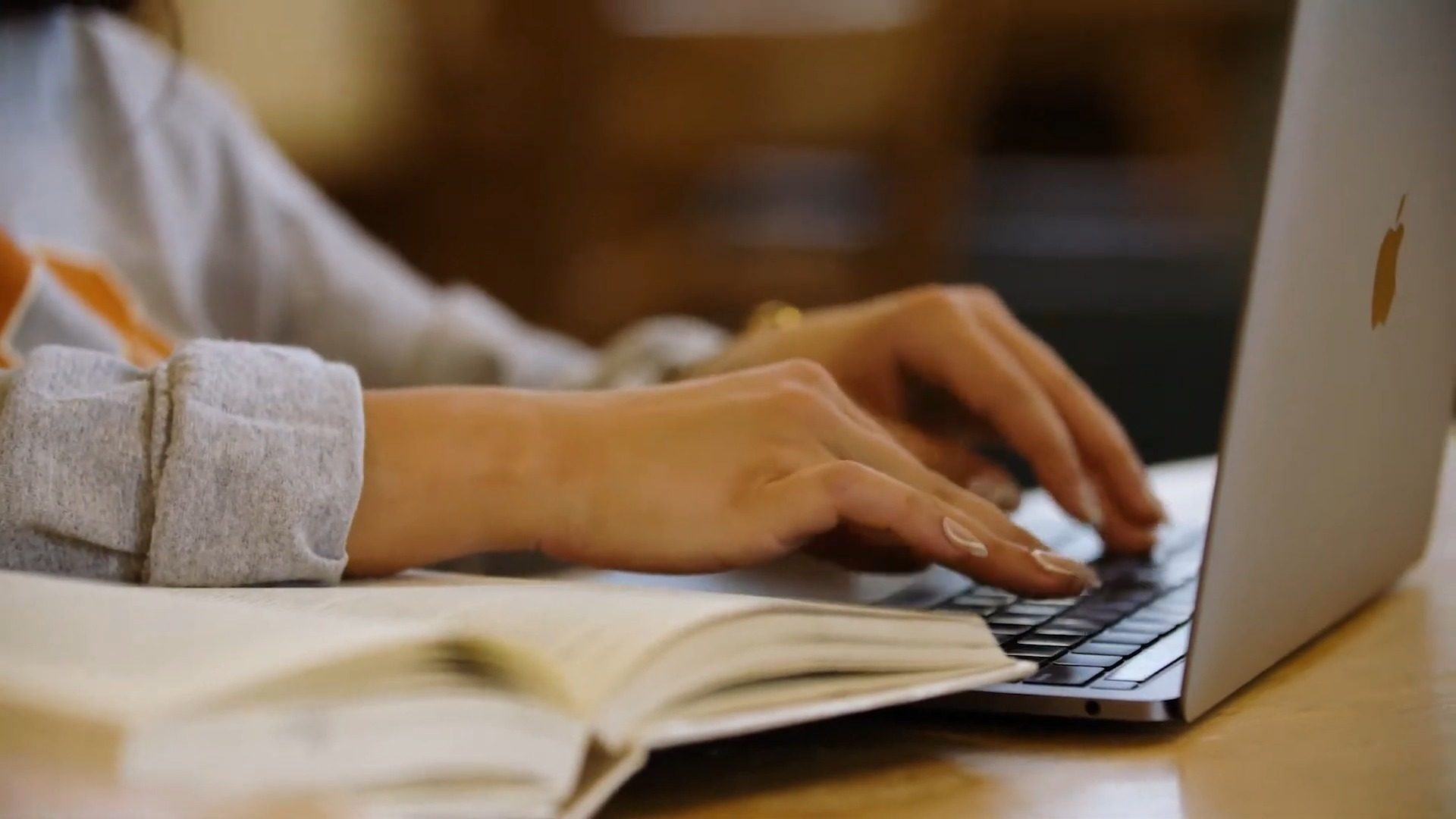 student typing on a laptop in a library