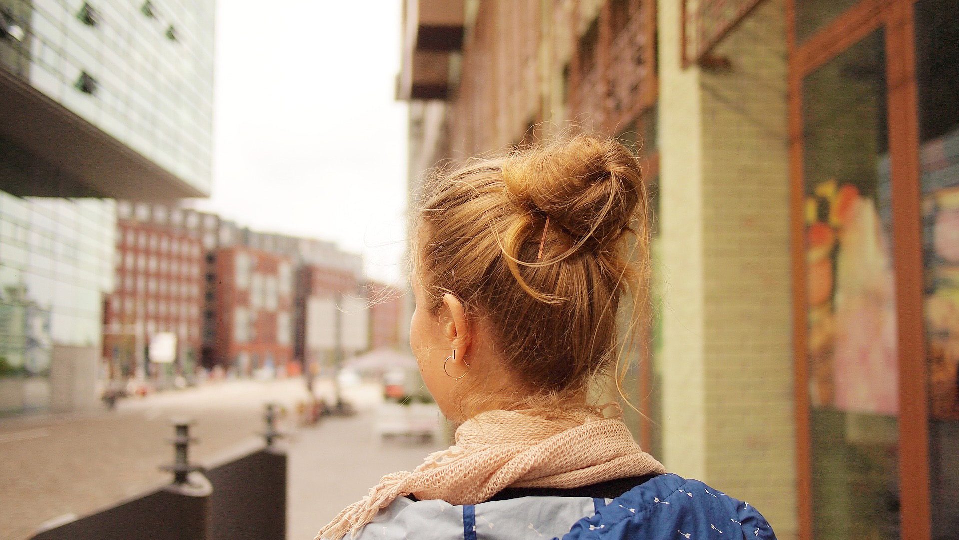 A woman with a backpack walking down a street.