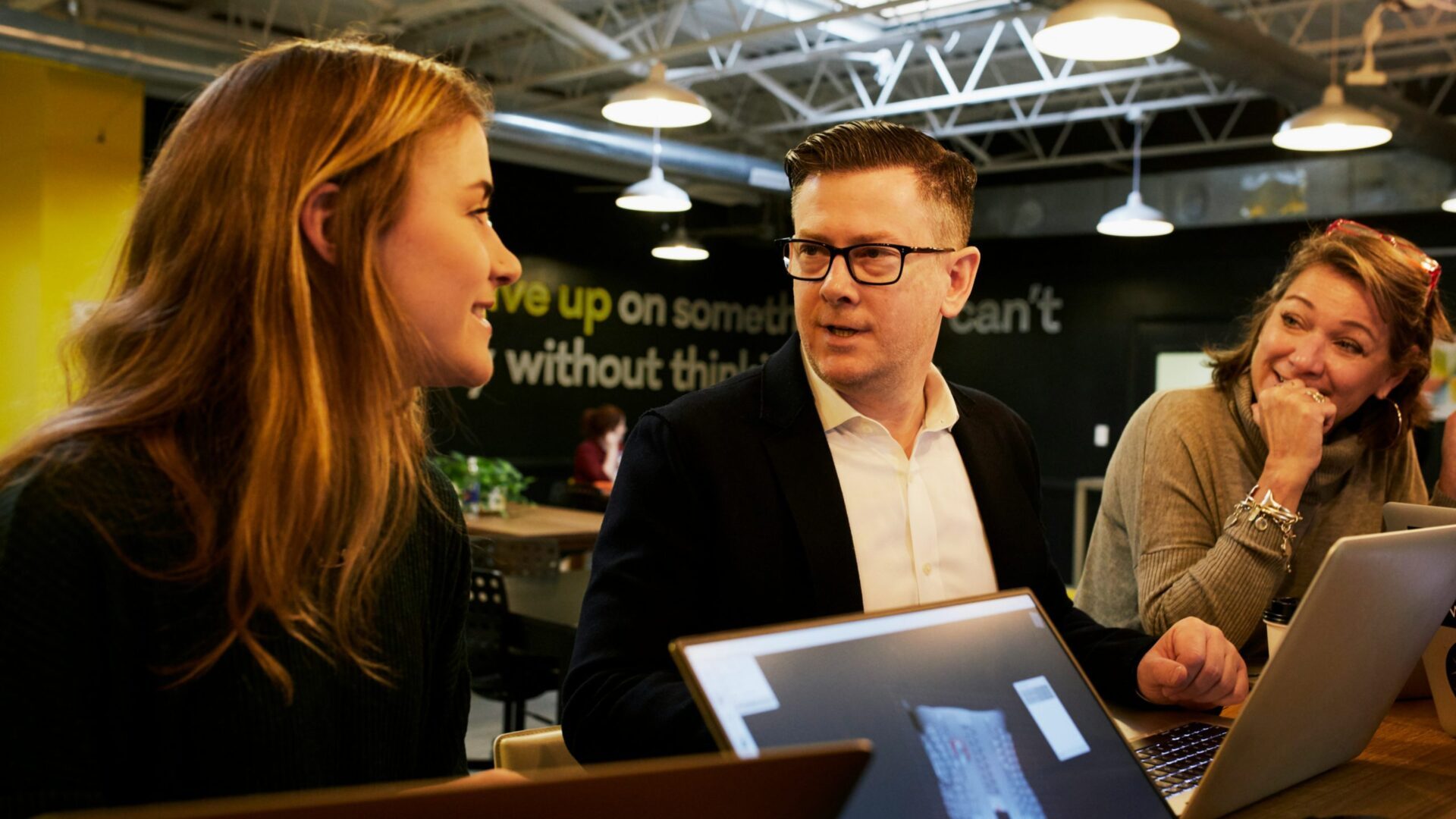 Three people having a conversation in an office.