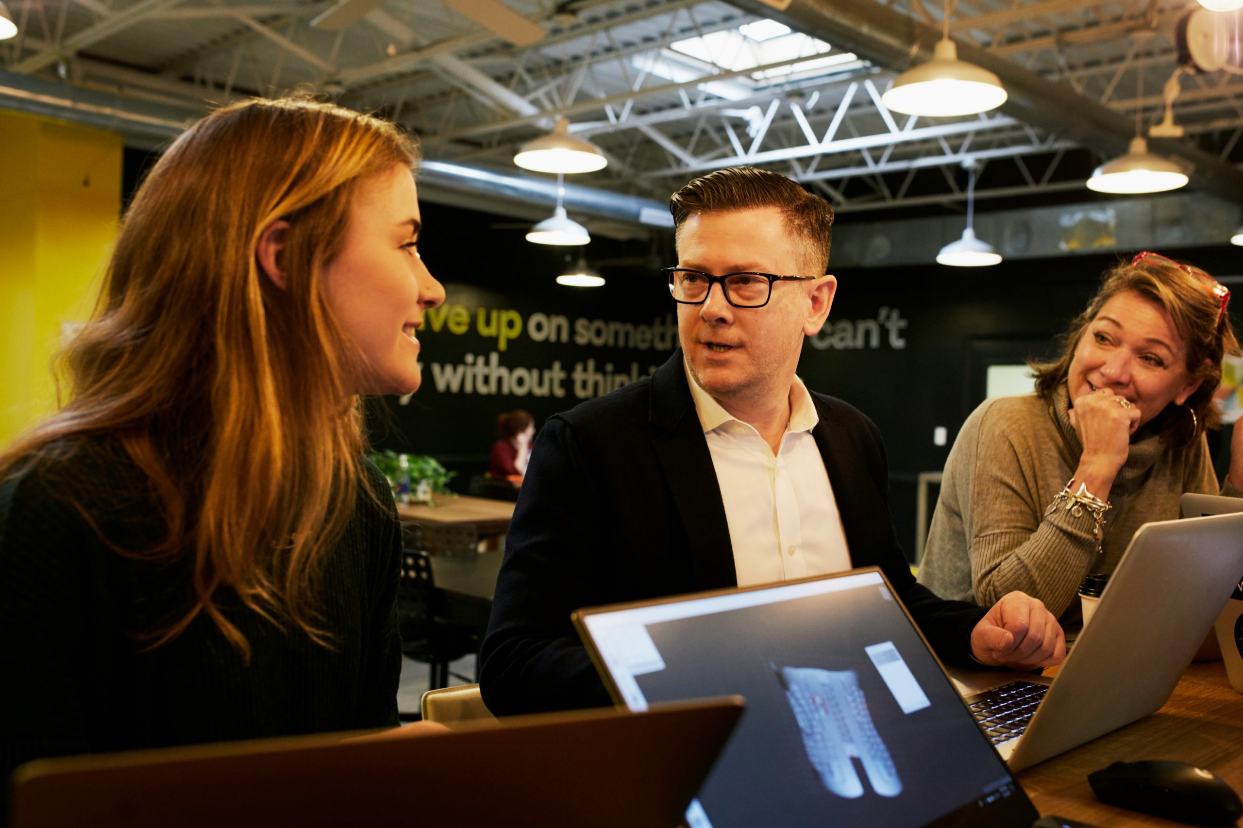 Three people having a conversation in an office.