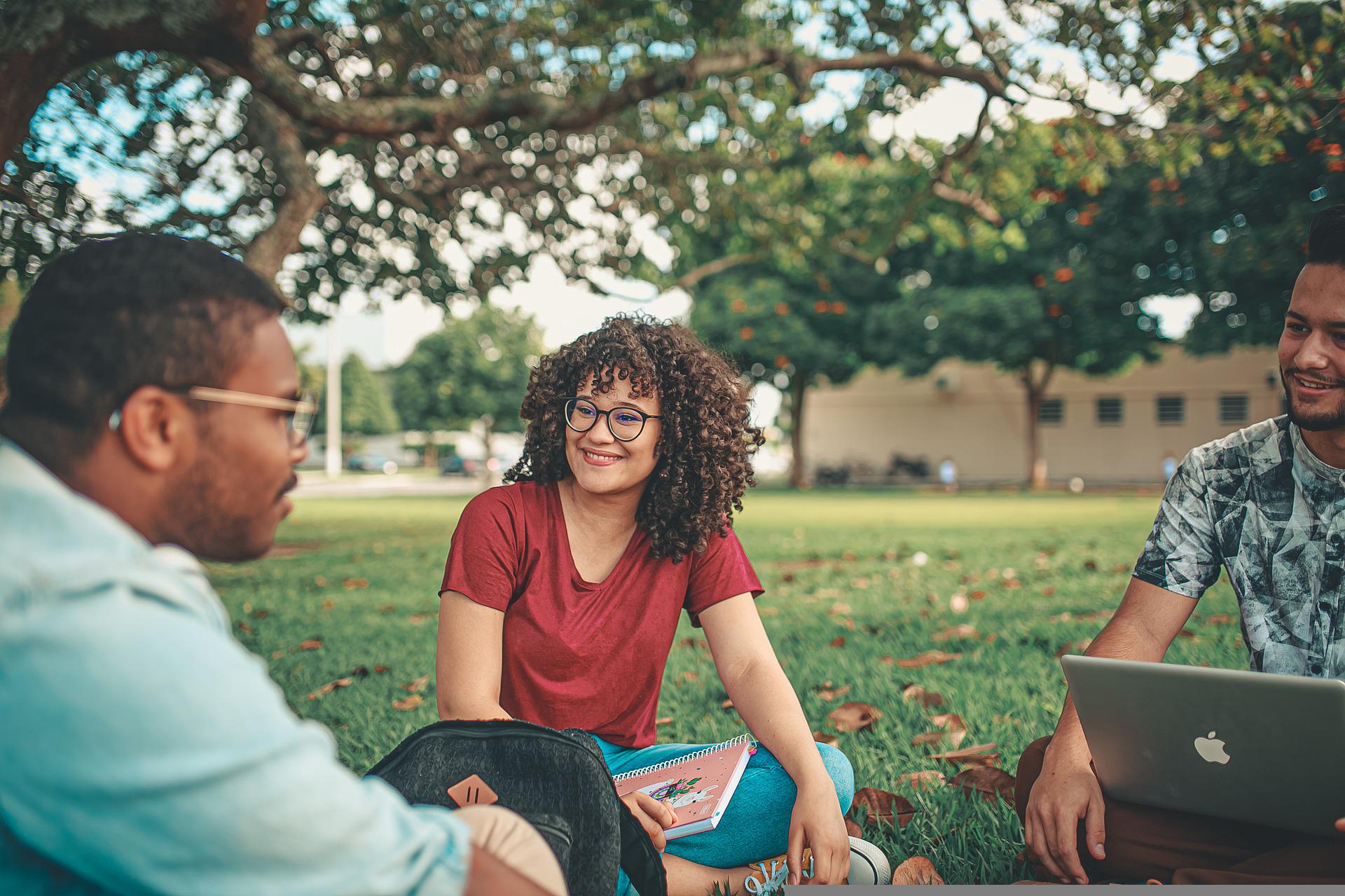 Students sitting in a field.