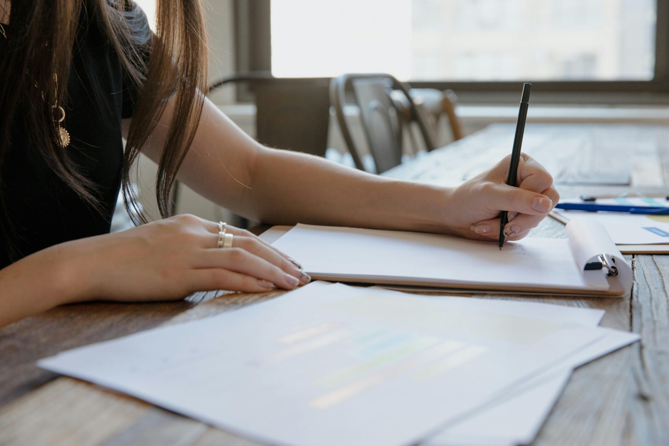 Student writing on a pad of paper.