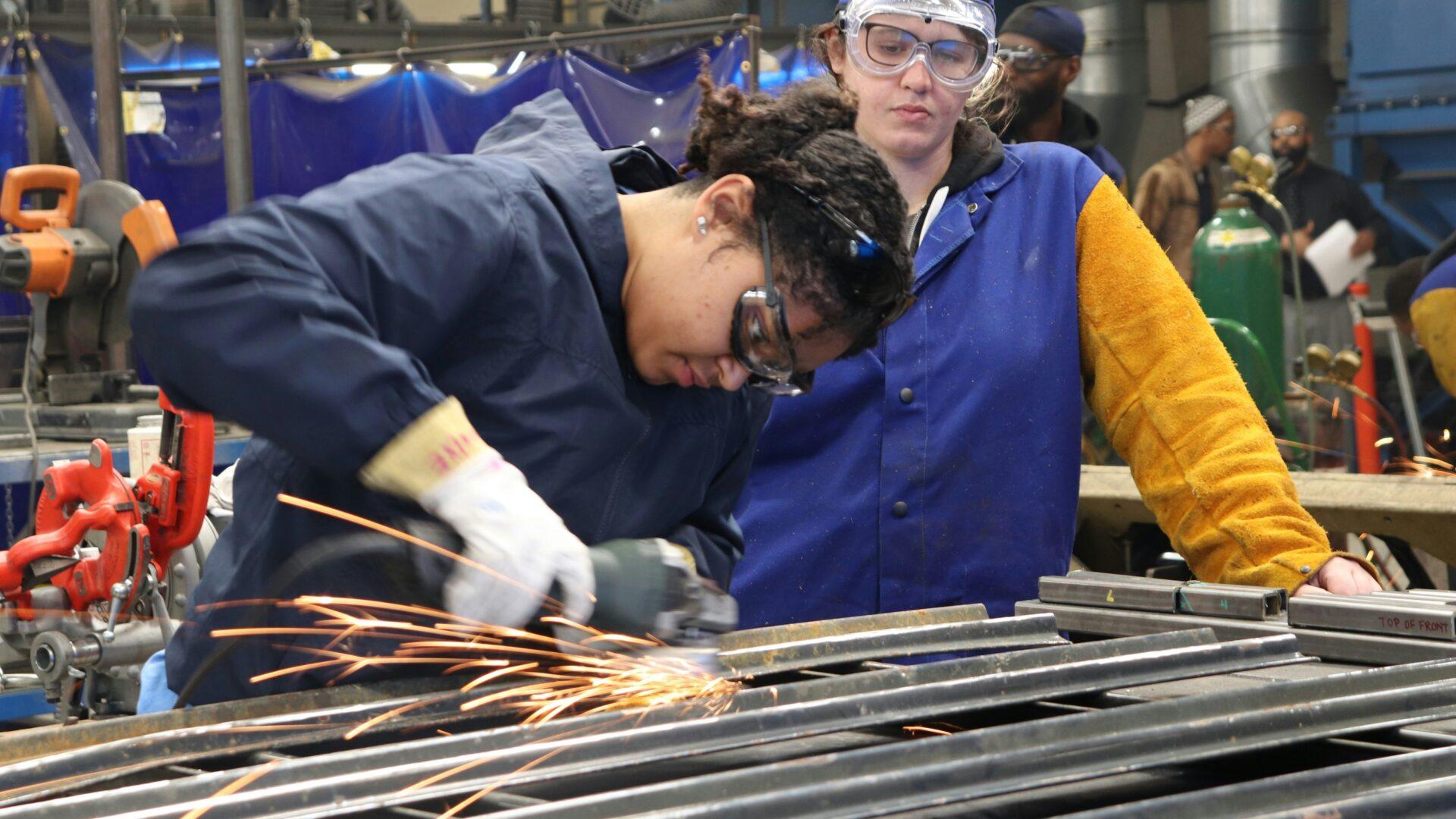 two students in a vocational classroom doing welding