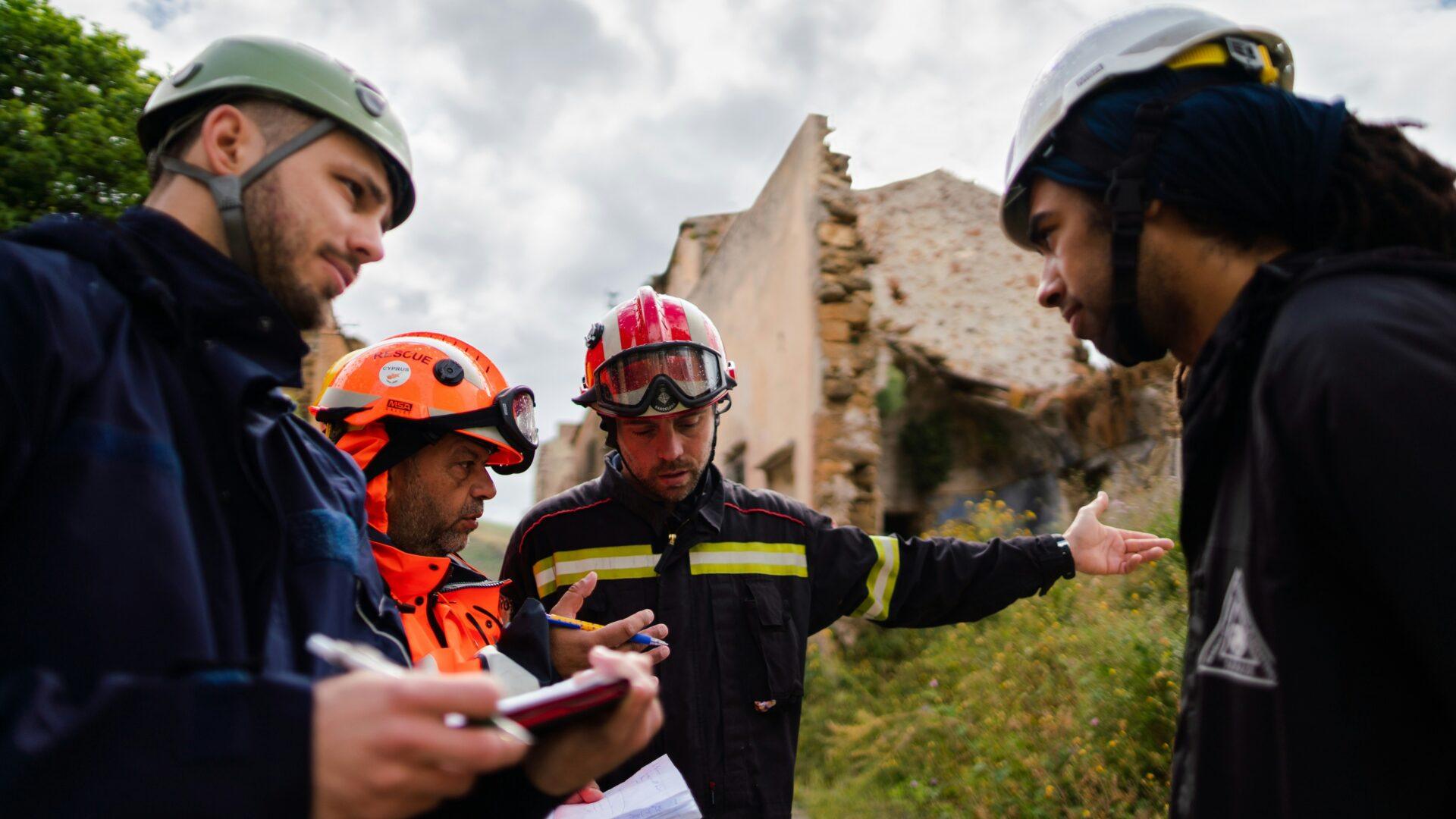 Group of engineering students in hard hats surveying a site