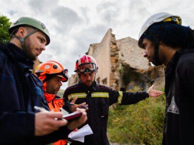 Group of engineering students in hard hats surveying a site