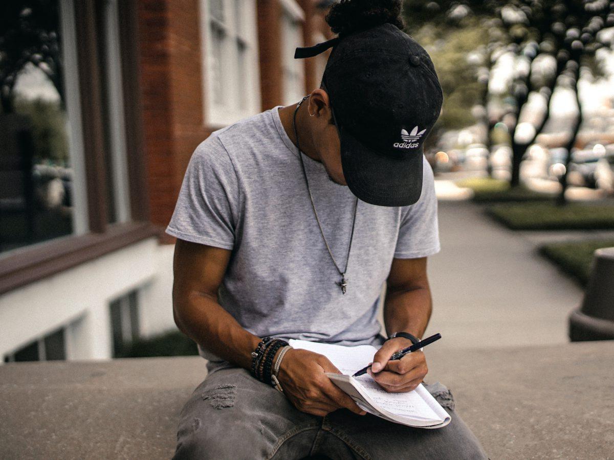 young male student writing in a notebook