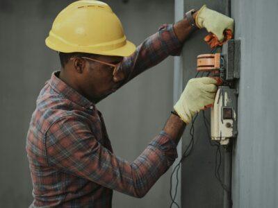 profile photo of an electrician in a yellow hard hat working