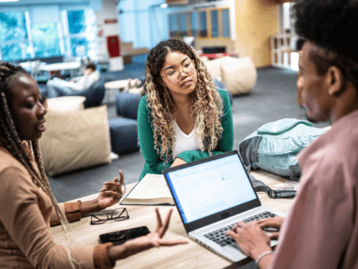 students around a computer discussing scholarship applications